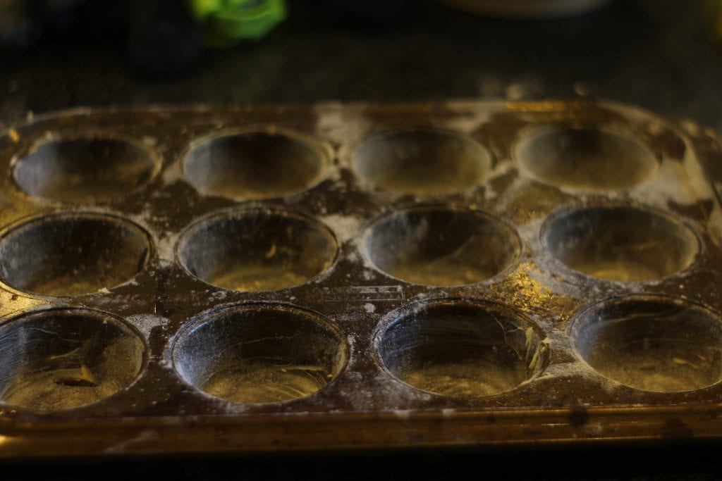 A greased and floured muffin tray