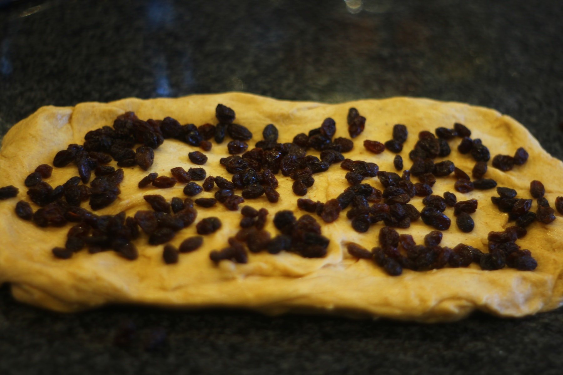 Adding the rasins Adding raisins to the dough