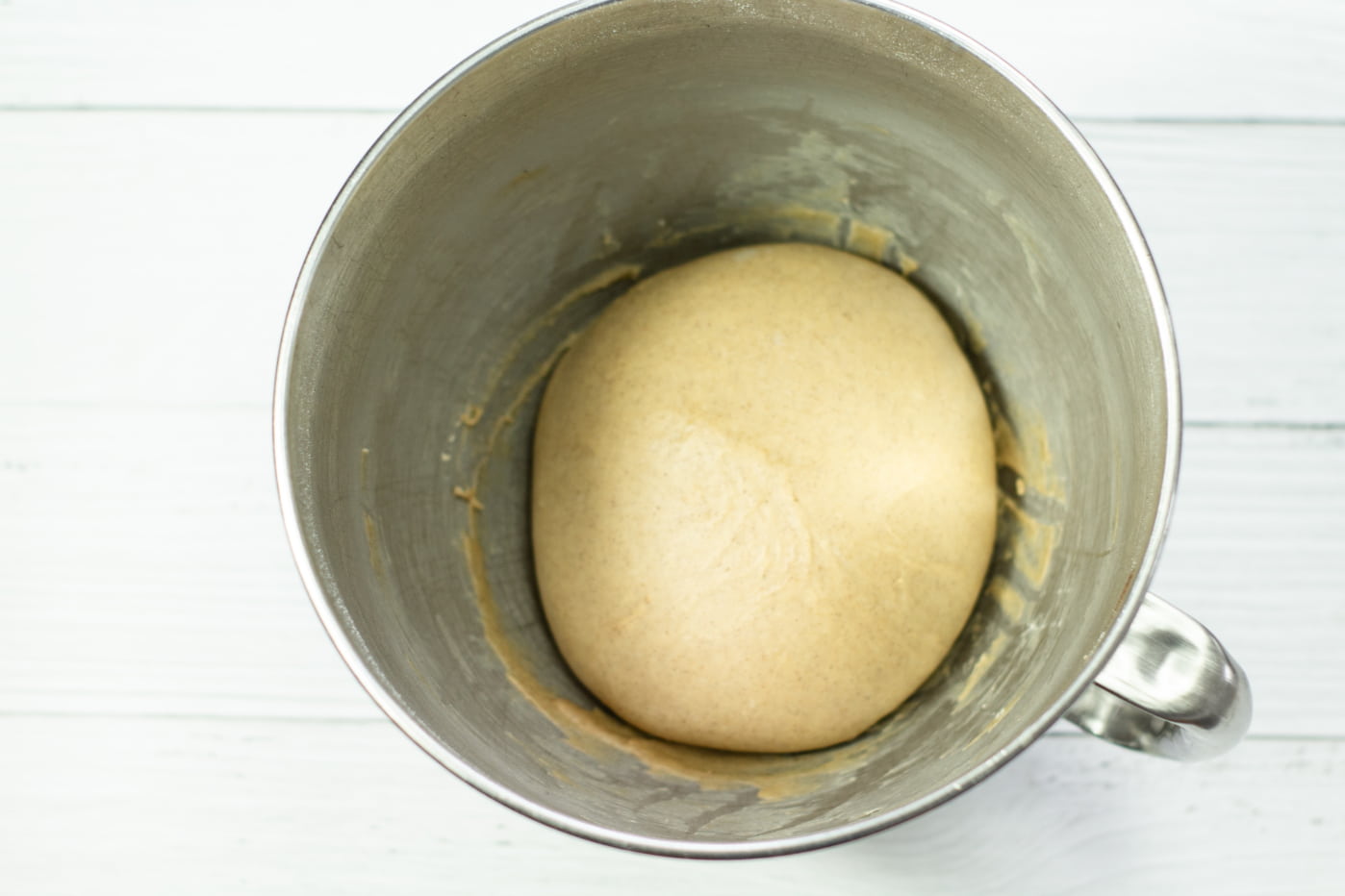 beige dough in a large steel mixing dough