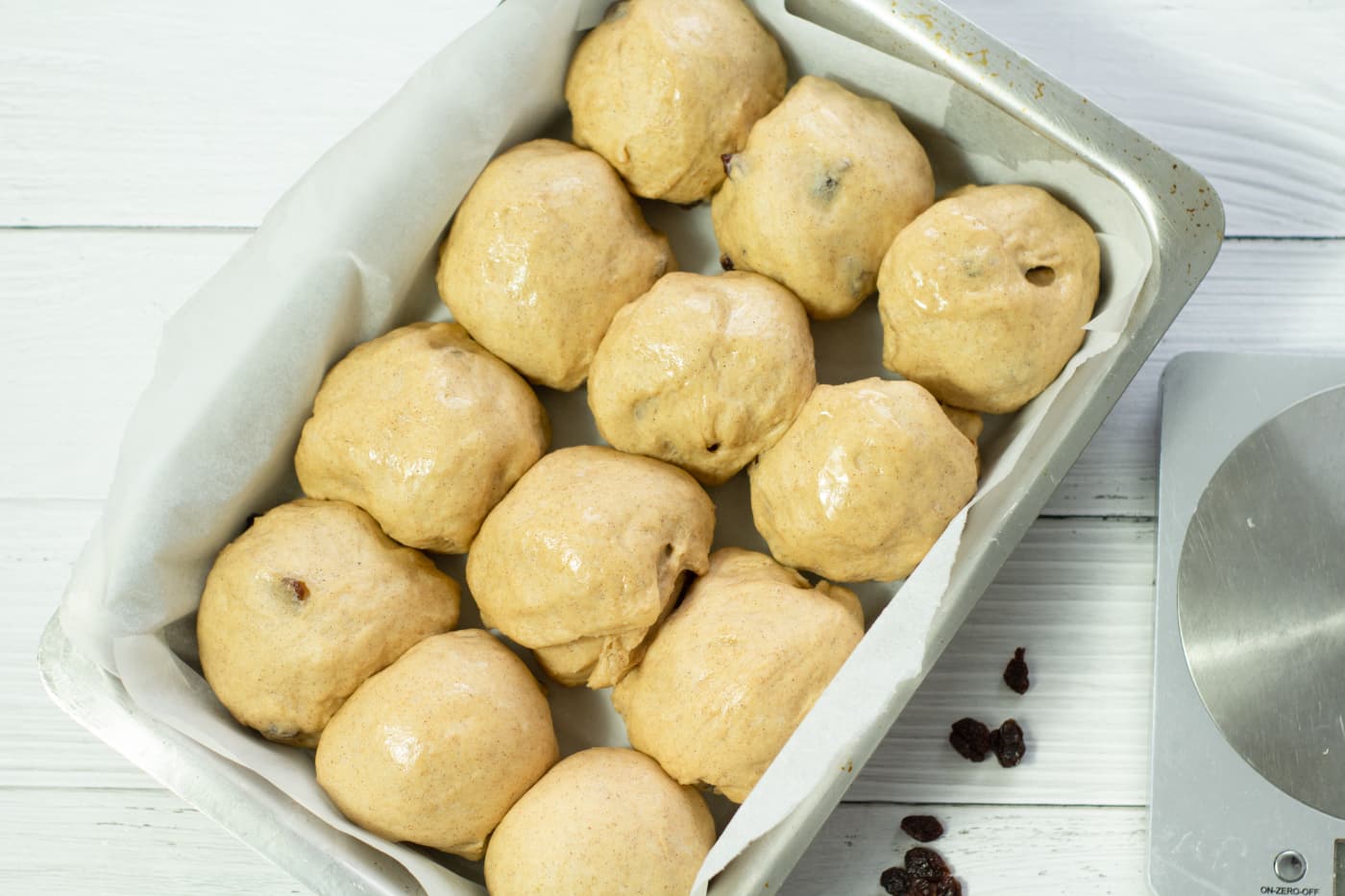 hot cross buns puffed up after second prove in a baking tray