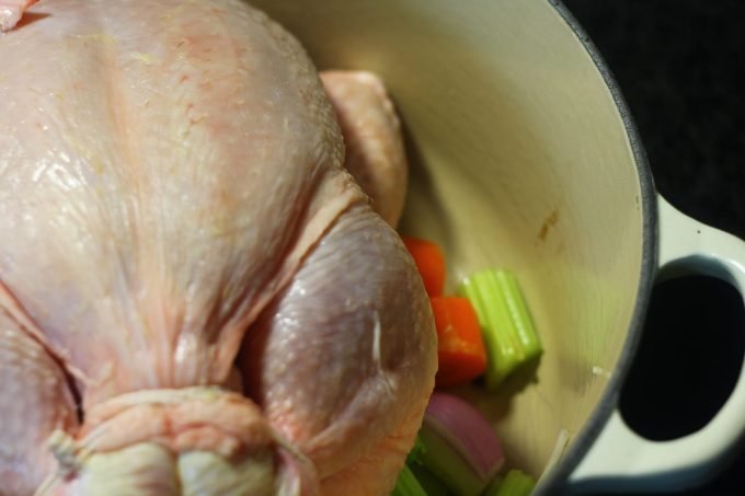 whole chicken and vegetables in a saucepan