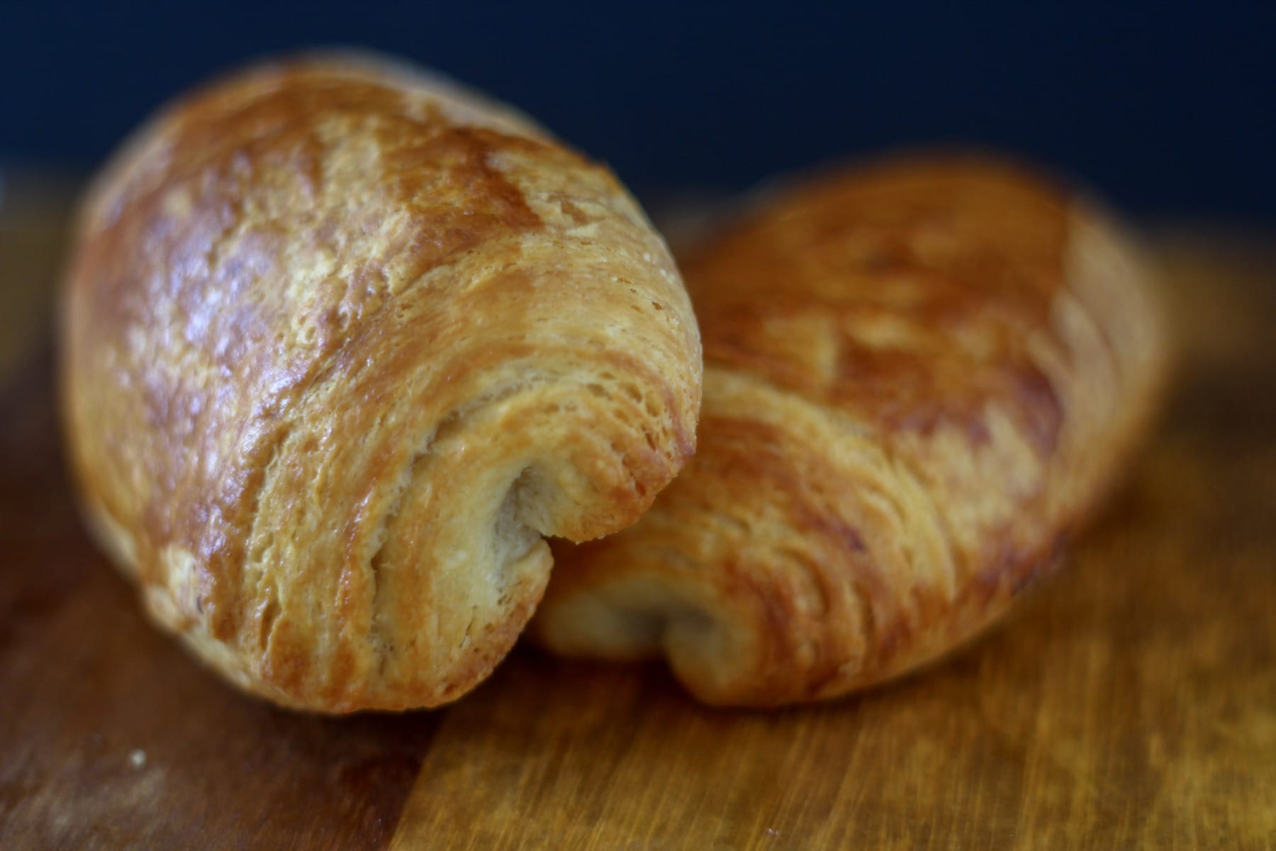 two pain au chocolat on a wooden board