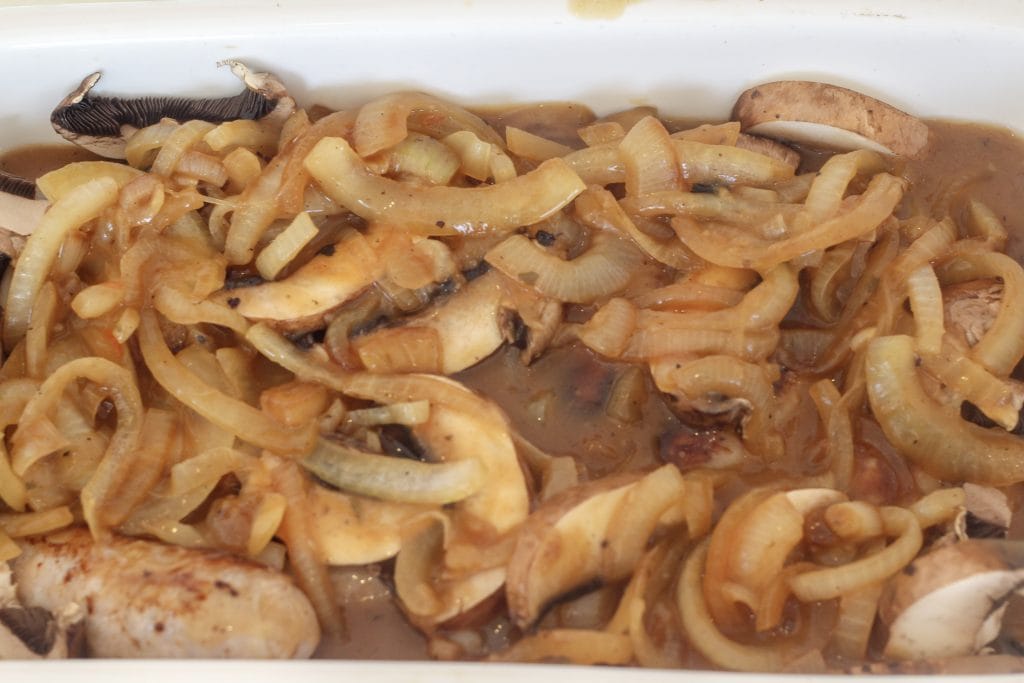 Sausages, onions, mushrooms and gravy Sausages, onions, mushrooms and gravy in the baking dish