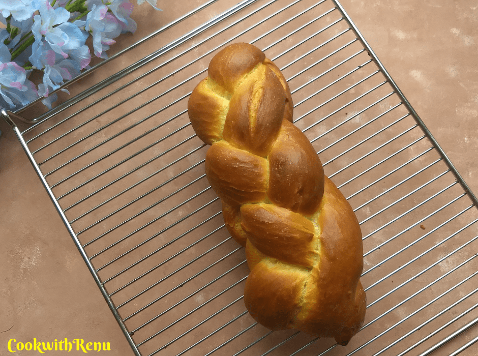 plaited eggless challah bread on a wire rack