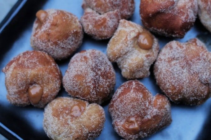 deep fried doughnuts filled with carnation caramel and dusted in xmas spices