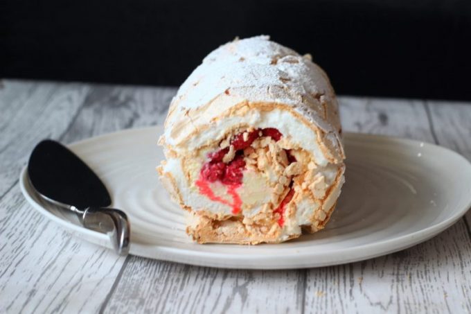 white chocolate and raspberry meringue roulade on a plate