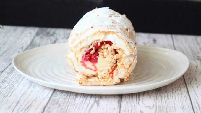 rolled up white chocolate and raspberry roulade on a serving dish