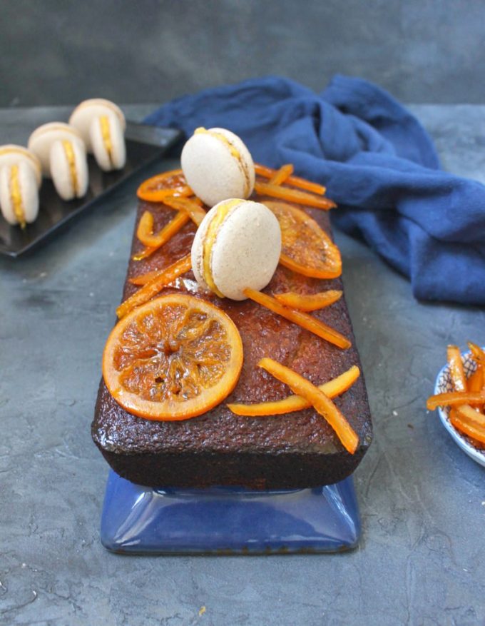 Orange Glazed Spiced Honey Cake on a blue plate and covered with sliced oranges