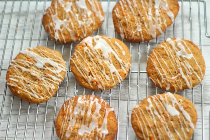 carrot cake cookies drizzled with cream cheese icing on a wire rack