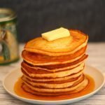 stack of pancakes covered in syrup and butter on a plate
