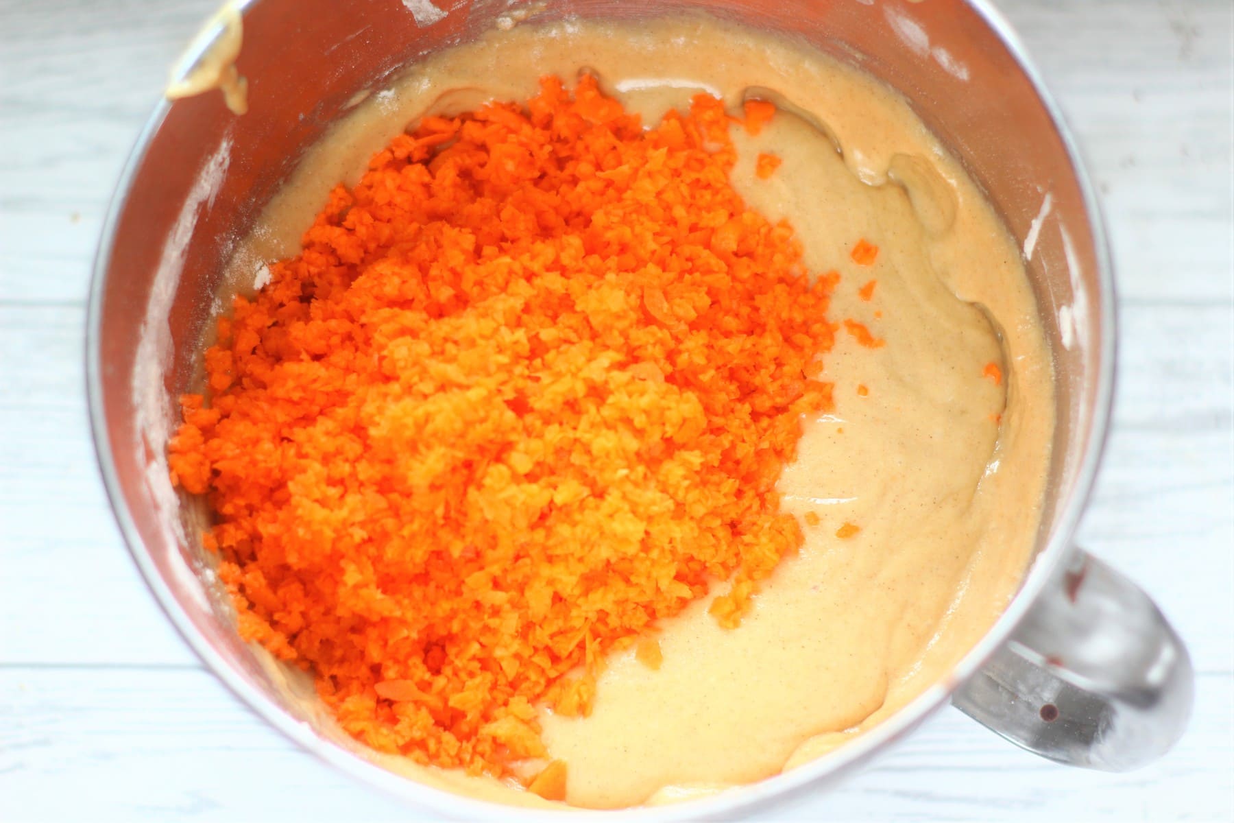 Grated carrot on top of the cake batter.