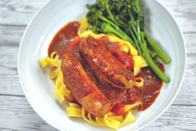 slow cooker sausage casserole and green vegetables served on fresh egg pasta