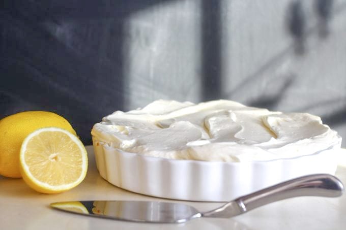 lemon cheesecake with lemons and a serving slice by the side