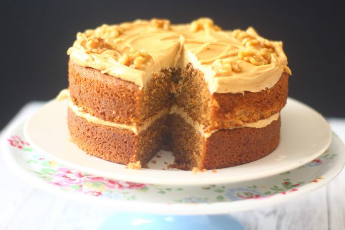 Coffee and Walnut Cake on a cake stand with a slice missing