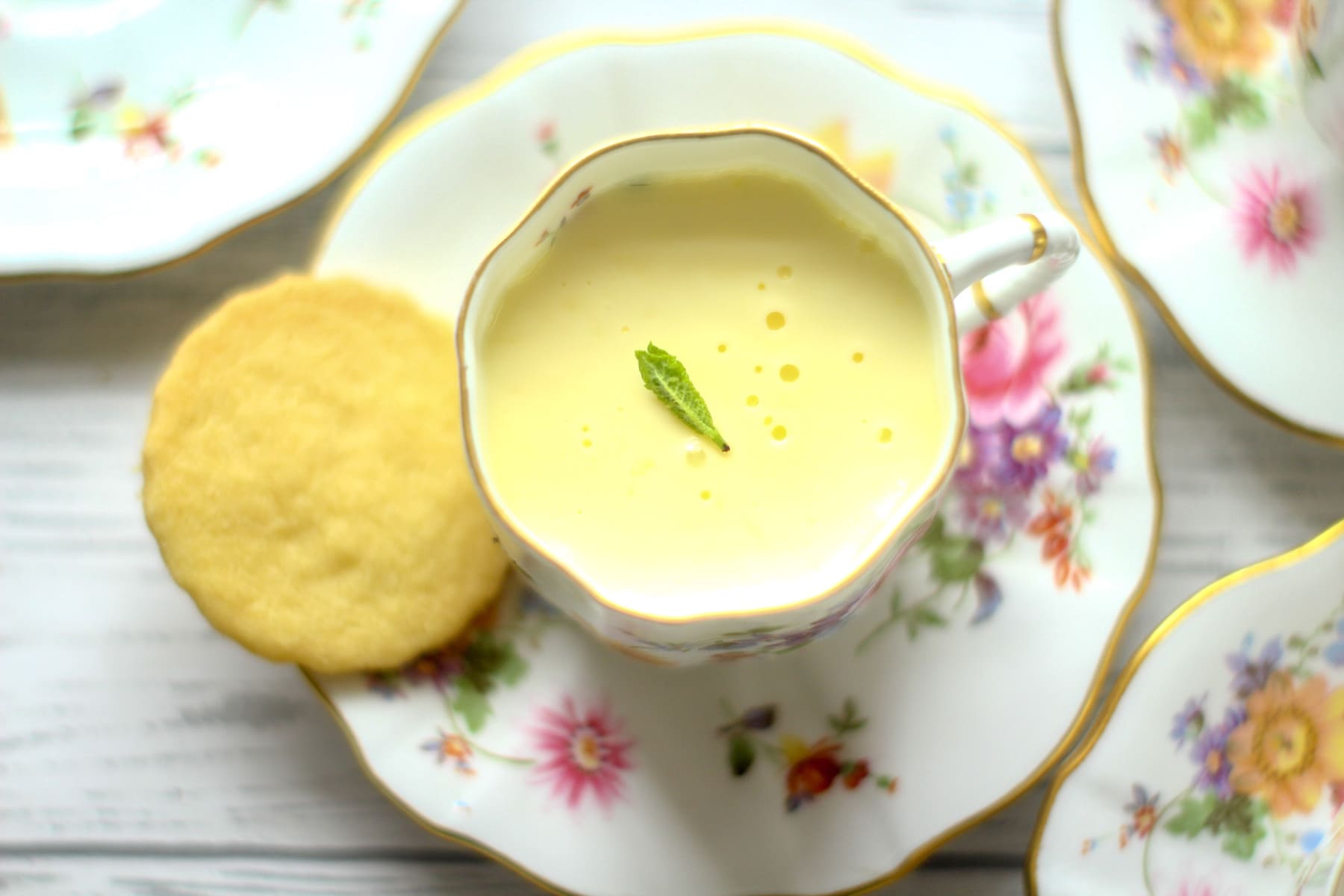 lemon posset in a teacup with a shortbread biscuit
