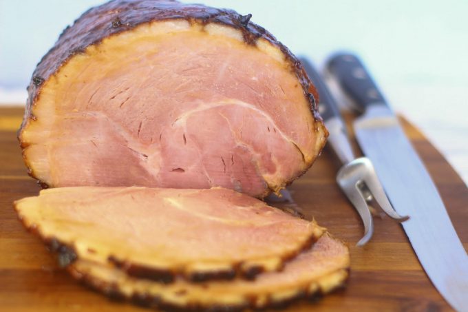 sliced gammon on a wooden chopping board