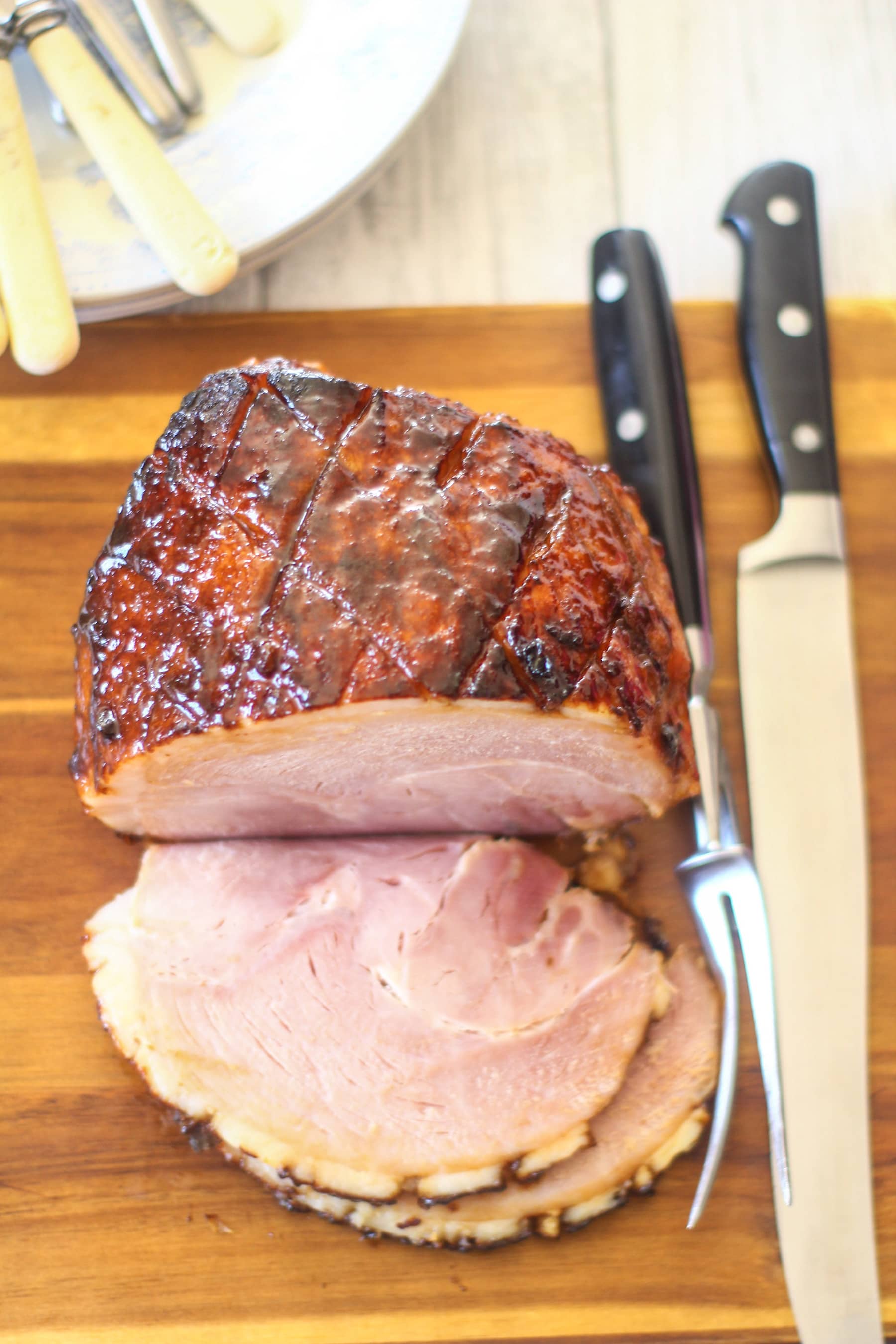 slow cooker gammon joint sliced on a wooden chopping board
