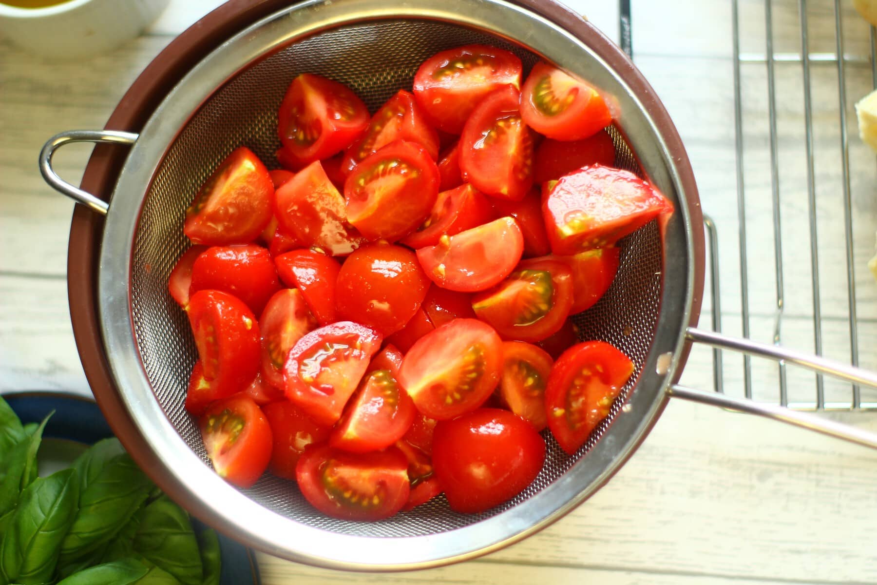 quartered salted tomatoes in a sieve
