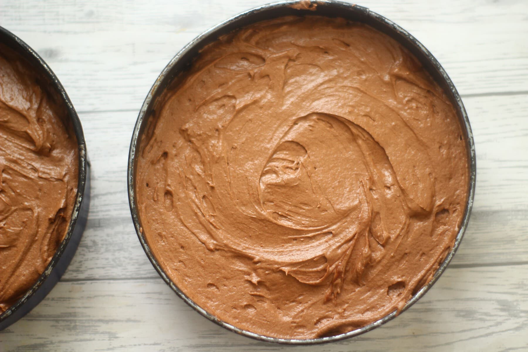 chocolate cake batter in cake tins