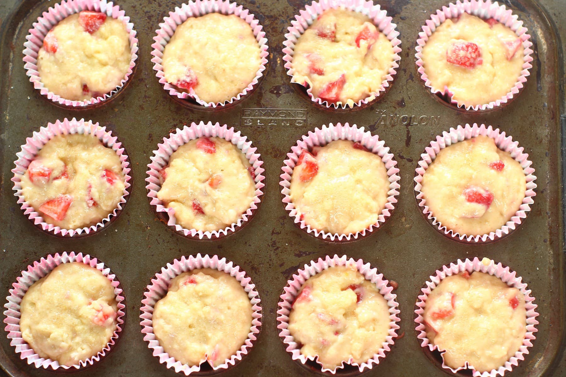 strawberry muffin batter in muffin tray