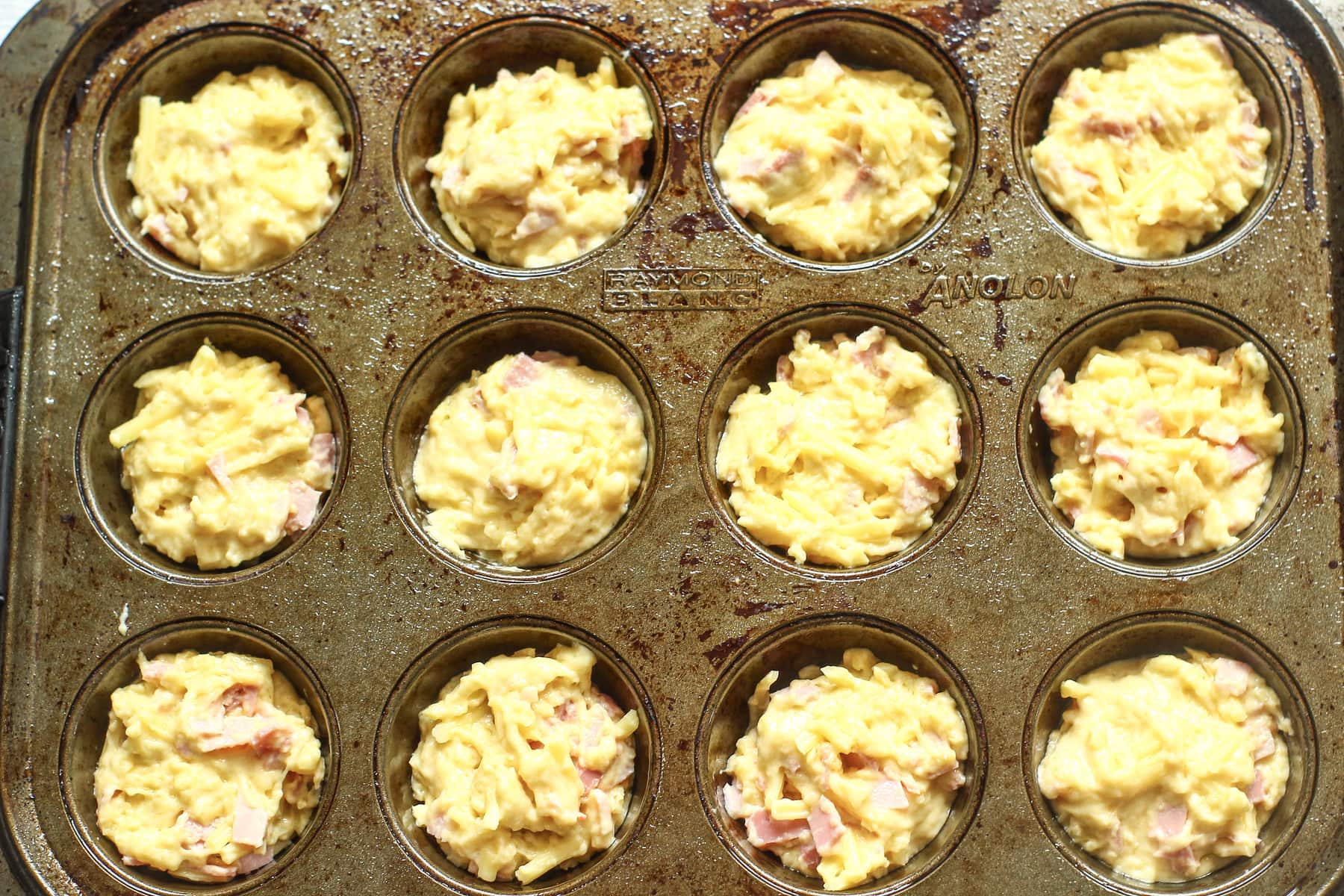 ham and cheese savoury muffin batter mix in a muffin tray