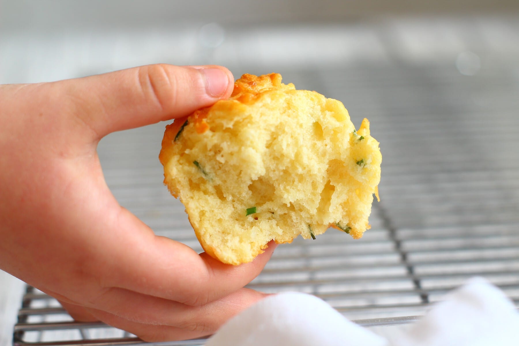 savoury cheese and chive muffin held in a hand