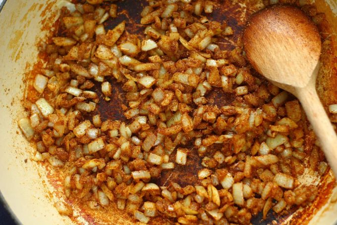 onions and spices sweating in a frying pan