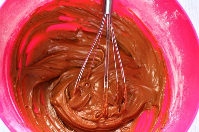 chocolate icing in a bowl with a whisk