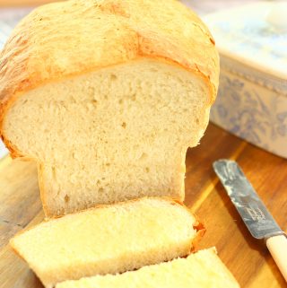 easy white bread on a wooden board with a butter knife and butter