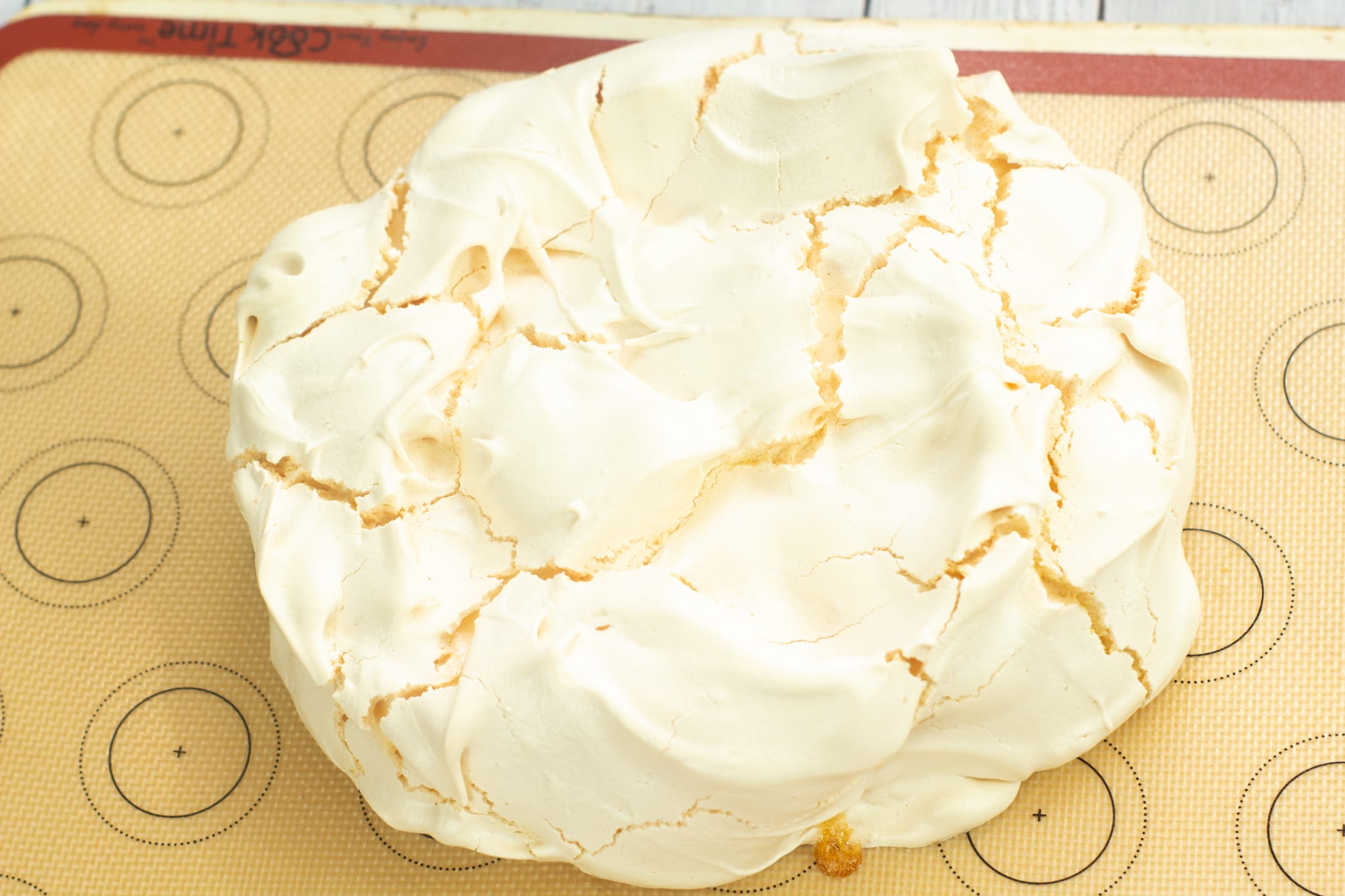 baked meringue pavlova on a lined baking tray
