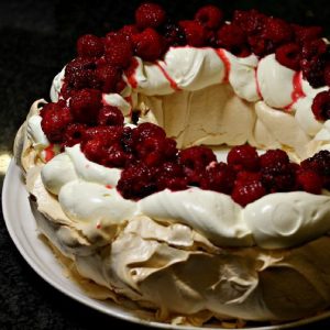 christmas pavlova topped with cream and berries