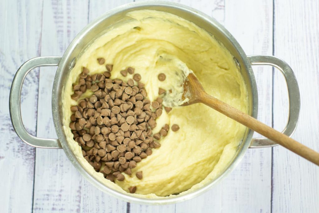 chocolate chips on top of cake batter in a saucepan