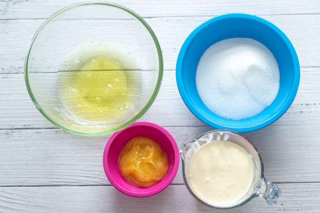 egg whites, caster sugar, lemon curd and double cream in bowls on a white surface