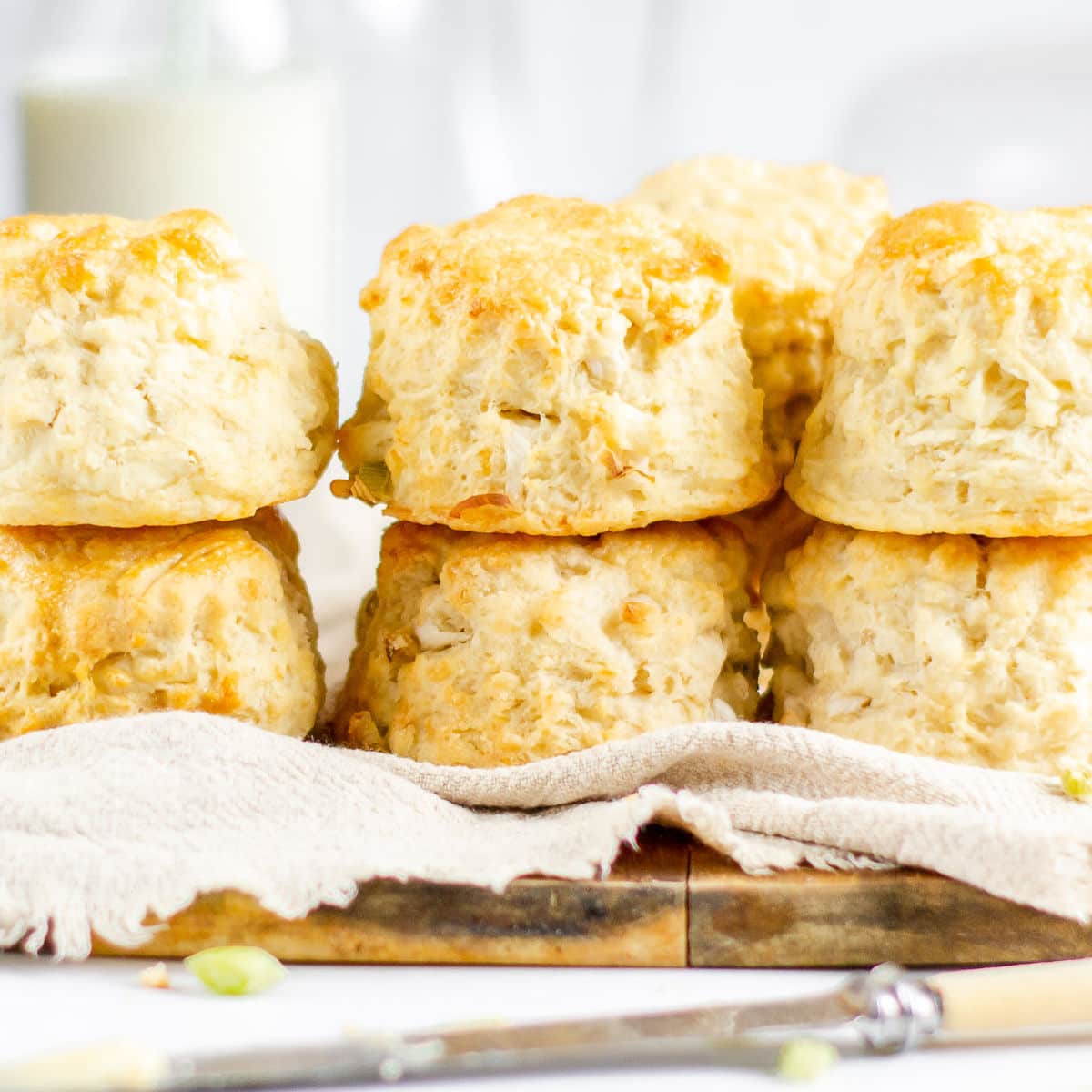 cheese and onion scones stacked two high on a wire cooling rack and grey napkin