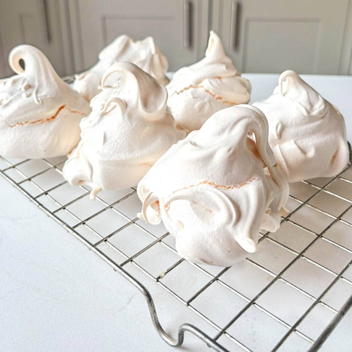meringues on a wire rack on white surface