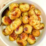new potatoes roasted in a white round lipped serving dish