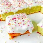 old school sprinkle cake cut into squares on a white surface
