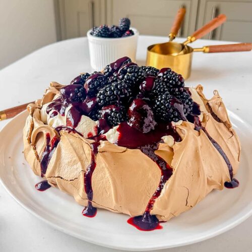 easy brown sugar & blackberry pavlova on a white serving plate